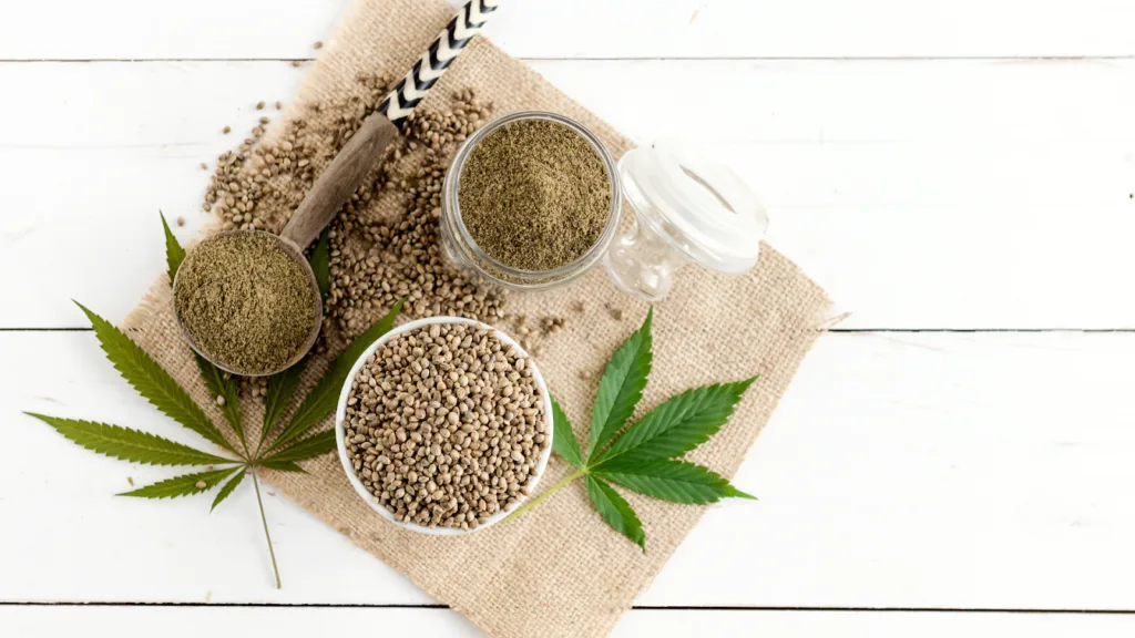 Hemp seeds and leaves on a burlap surface